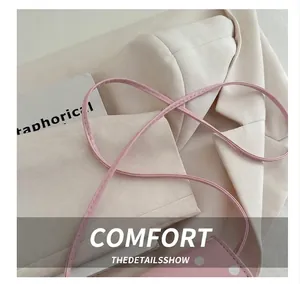 Detail of the soft pink shoulder bag showing the slim PU leather strap and fine stitching