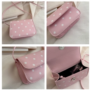 Detailed views of a pink polka dot mini crossbody bag showing interior capacity and details