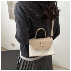 Rear view of a model wearing a two-tone white and beige crossbody square bag with gold lock