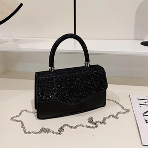 Schwarze Pailletten-Handtasche mit Metallkette und glattem Lederfinish auf weißem Sockel