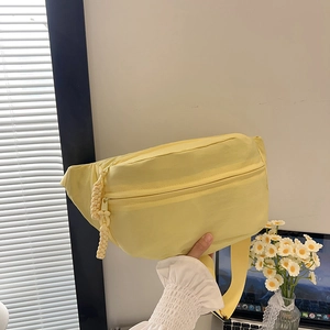 Light yellow casual crossbody bag made of durable nylon with stylish woven zipper pulls