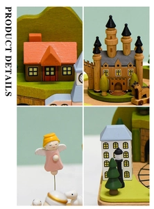 Detail view of a handcrafted wooden music box featuring castle and angel figurines