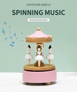 Détail d'une boîte à musique rotative en bois avec danseuses roses et carrousel