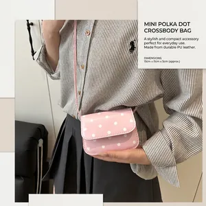 Detailed look at pink polka dot crossbody bag with leather texture on female model