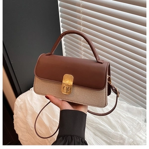 Detail der braun-beigen Handtasche mit goldenem Metalldrehverschluss für Damen