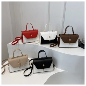 Detail view of five assorted color faux leather crossbody bags on display stands