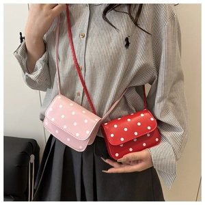 Detail of pink and red polka dot mini crossbody bags with flap closure and matching straps