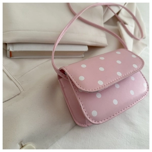 Detailed close-up of pink polka dot mini crossbody bag with a smooth PU leather finish