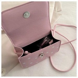 Detail view of pink polka dot mini bag with magnetic clasp and interior capacity