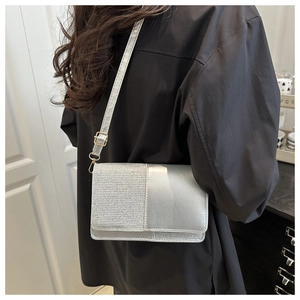 Silver glitter crossbody bag worn by model showing minimalist texture and metallic finish