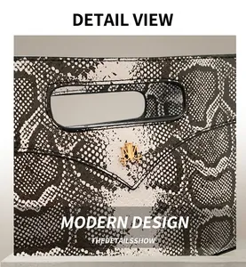 Detail der schwarz-weißen Schlangenhaut-Optik am Shopper mit goldenem M-Logo