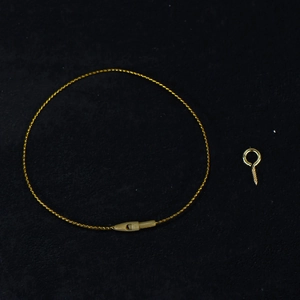 Close-up of golden braided hanging cord loop with screw eye pin for DIY wooden crafts