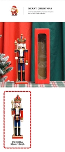 Close-up of 30cm wooden nutcracker king in red uniform with crown and scepter in gift box