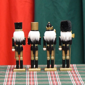 Set of four 18cm black and gold wooden nutcracker soldier Christmas ornaments on festive background