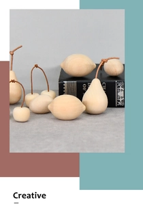 Close-up of minimalist wooden fruit models including pear and cherry with leather stems