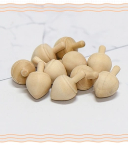 Dettaglio di piccoli accessori in legno naturale a forma di ghianda su fondo marmoreo