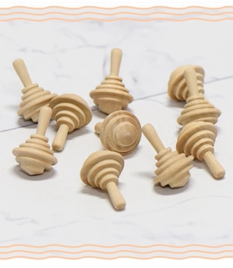 Flat lay of multiple unfinished wooden spinning tops on white marble background