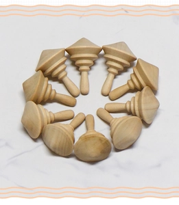 Flat lay of ten handcrafted unfinished wooden spinning tops in various unique shapes