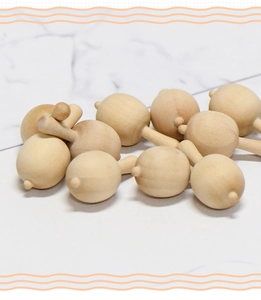 Close-up of unfinished smooth natural wood mini maraca DIY crafts and unpainted toy parts