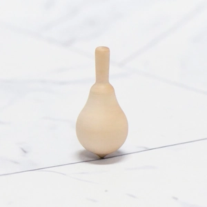 Minimalist DIY wooden spinning top toy with natural wood grain on marble background