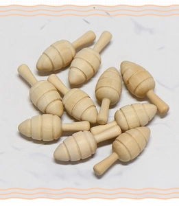 Dettaglio macro di dieci mini oggetti in legno artigianale con scanalature su marmo