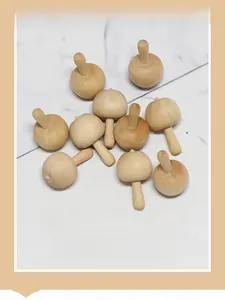 Detailed top view of 11 unfinished wooden spinning tops in a cute mushroom shape for DIY