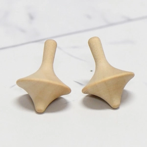 Ensemble de toupies artisanales en bois naturel pour peinture DIY sur marbre blanc