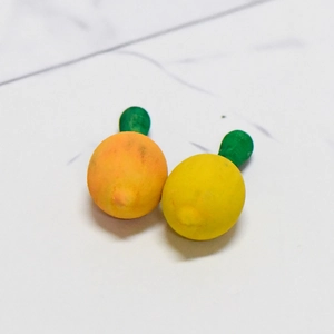DIY lemon resin charms in yellow and orange with green leaves for creative crafts