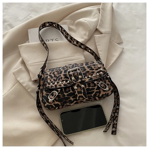 Detail of leopard print baguette bag featuring metallic studs and decorative buckle