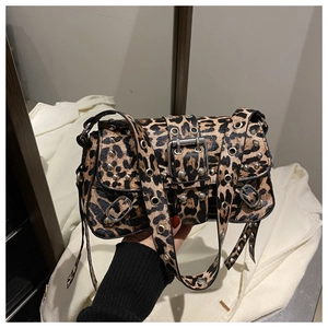 Détail du sac léopard avec rivets argentés et œillets métalliques sur la bandoulière