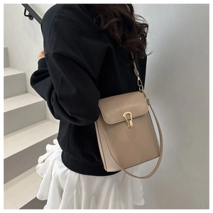 Détail du sac seau beige avec fermoir fer à cheval doré et cuir mat de haute qualité