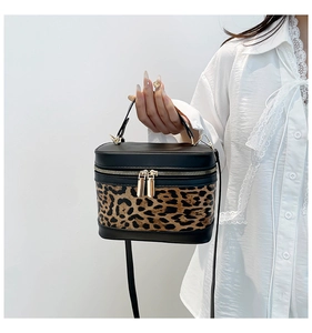 Model wearing a vintage leopard print bucket bag with gold zippers and black PU leather