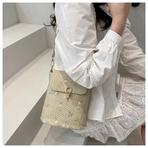 Dettaglio del ricamo in pizzo floreale e fibbia dorata vintage sulla borsa a tracolla