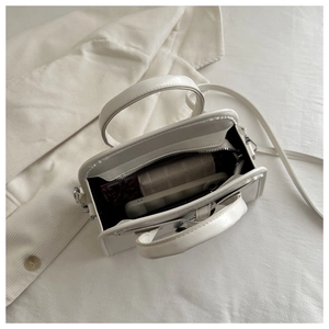 Overhead view of white minimalist handbag interior showing spacious capacity and pocket
