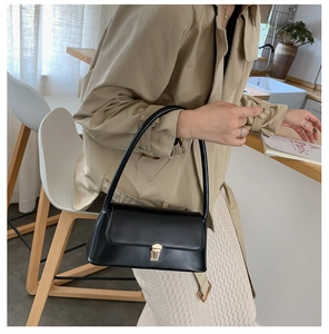 Détail du sac sous l'aisselle en cuir noir avec une élégante boucle carrée dorée chic