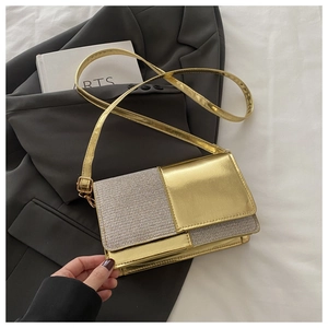 Détail du sac à bandoulière à paillettes dorées et argentées sur fond blanc épuré