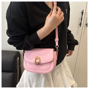 Detalle de bolso silla de montar en charol rosa con hebilla de metal dorado grande