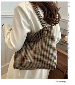 Side view of a vintage plaid tote bag in textured tweed, styled with a white blazer for work