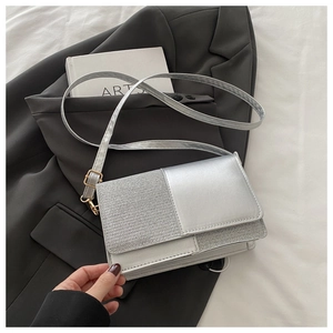 Détail du cuir argenté métallisé et tissu pailleté sur ce petit sac bandoulière