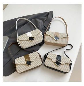 Quatre sacs à bandoulière en paille tressée avec boucles métalliques sur une table