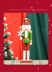 Détail d'un casse-noisette de 38cm en bois avec uniforme vert et bâton flocon de neige