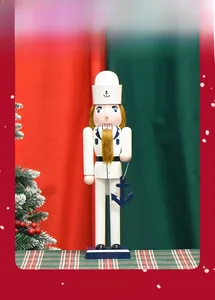 Close-up of wooden sailor nutcracker in white uniform holding a blue anchor ornament