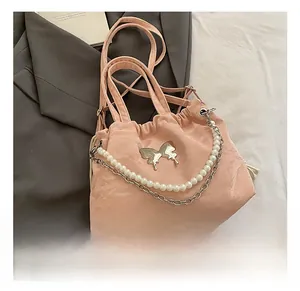 Detail of pink drawstring handbag with silver butterfly metal logo and pearl chain strap