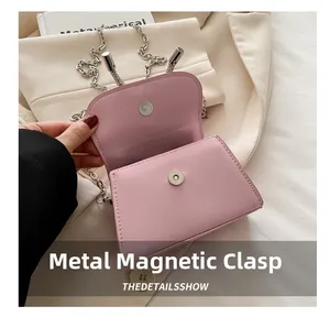 Detailweergave van de roze mini-tas met metalen magneetsluiting en zilveren ketting