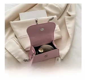 Binnenkant van roze mini-schoudertas met ruimte voor lippenstift en make-up compact