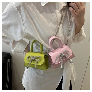 Détail de mini sacs bandoulière avec nœud en strass et chaînes métalliques