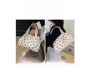 Detail view of strawberry print canvas tote bag showing both hand-carry and shoulder styles