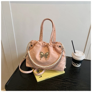 Detail of pink pleated bag with silver butterfly buckle and pearl chain decoration