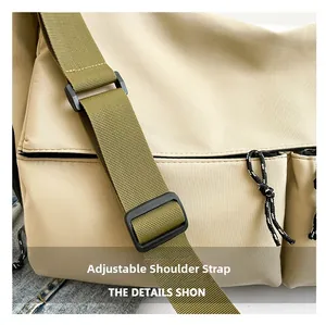 Detail of adjustable green shoulder strap on a beige nylon crossbody bag