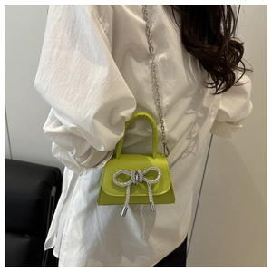 Détail du mini sac vert avec noeud en strass étincelant et bandoulière chaîne